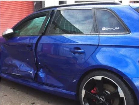 Blue Audi door damage before repair