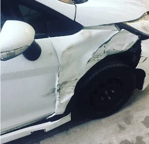 White Ford with accident damage before repair