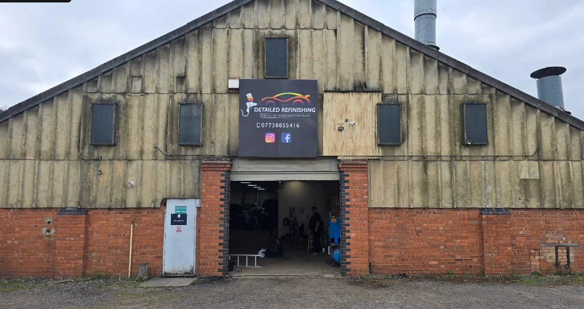 Detailed Refinishing workshop on Corn Mill Road, showing the business sign and bodyshop entrance