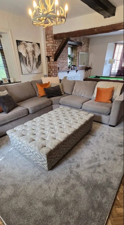 Lounge with new grey carpet under a corner sofa