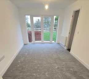 Empty room with new grey carpet and patio doors